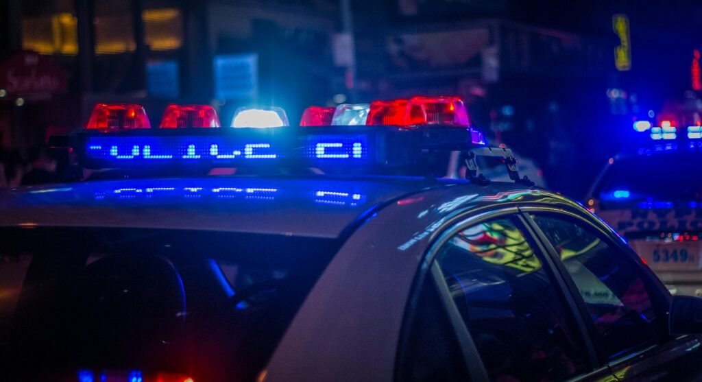 Police car with flashing emergency lights on a city street